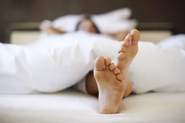 Une femme se repose dans son lit lors d'une grasse matinée.