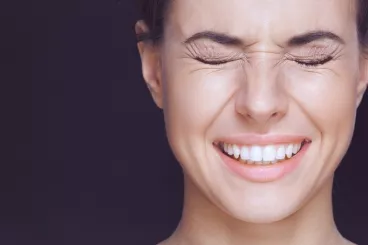 Une femme effectue de la gym du visage