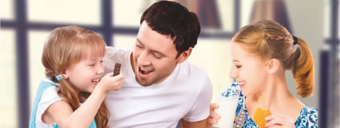 Une petite fille avec ses parents goûtent avec le chocolat Milka® Pâte de Noisette