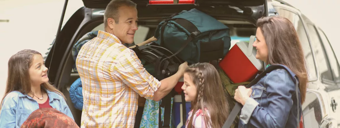 Le toit d’une voiture jaune chargé de vélos et bagages pour les vacances