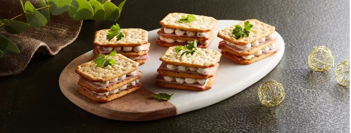 Mille-feuilles salé au jambon et biscuits TUC disposé sur un plateau